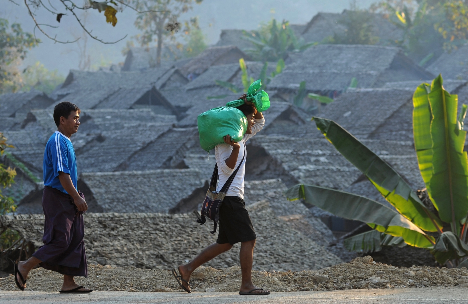 Refugees walk past Mae La camp in Thailand’s Tak province, near the Myanmar border, on January 29, 2012. (AFP)
