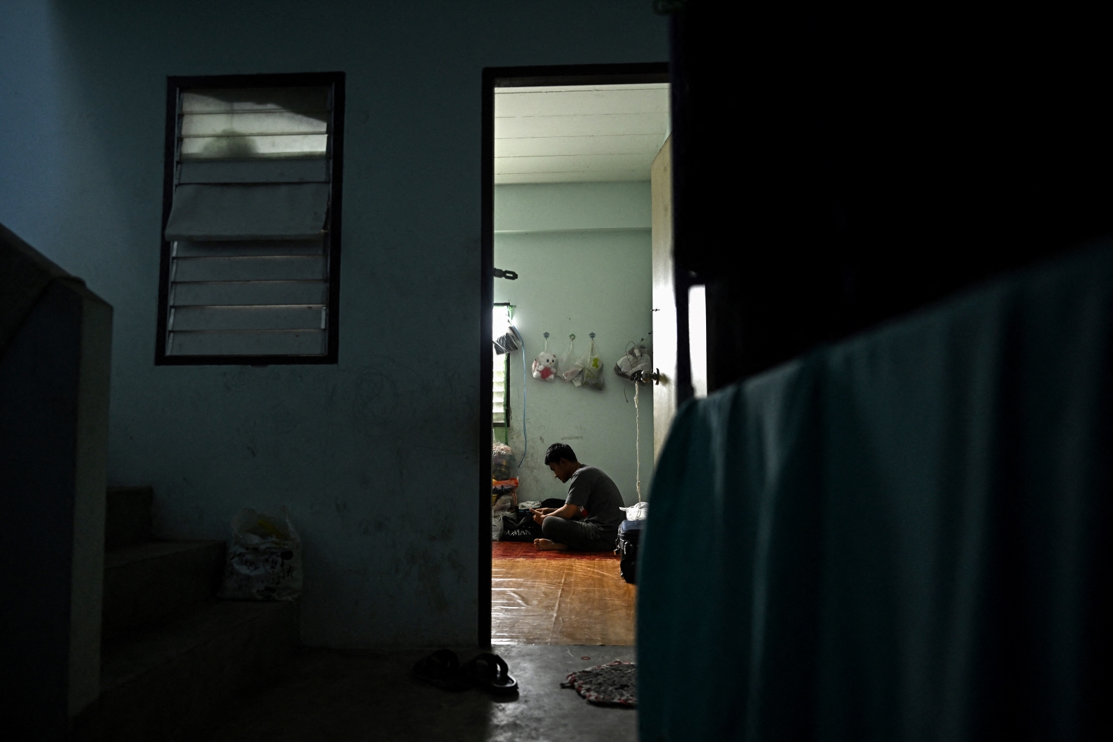 Myanmar migrant worker Ko Thura sits at his flat during a day off work in Thailand’s Samut Sakhon province on January 26. (AFP)