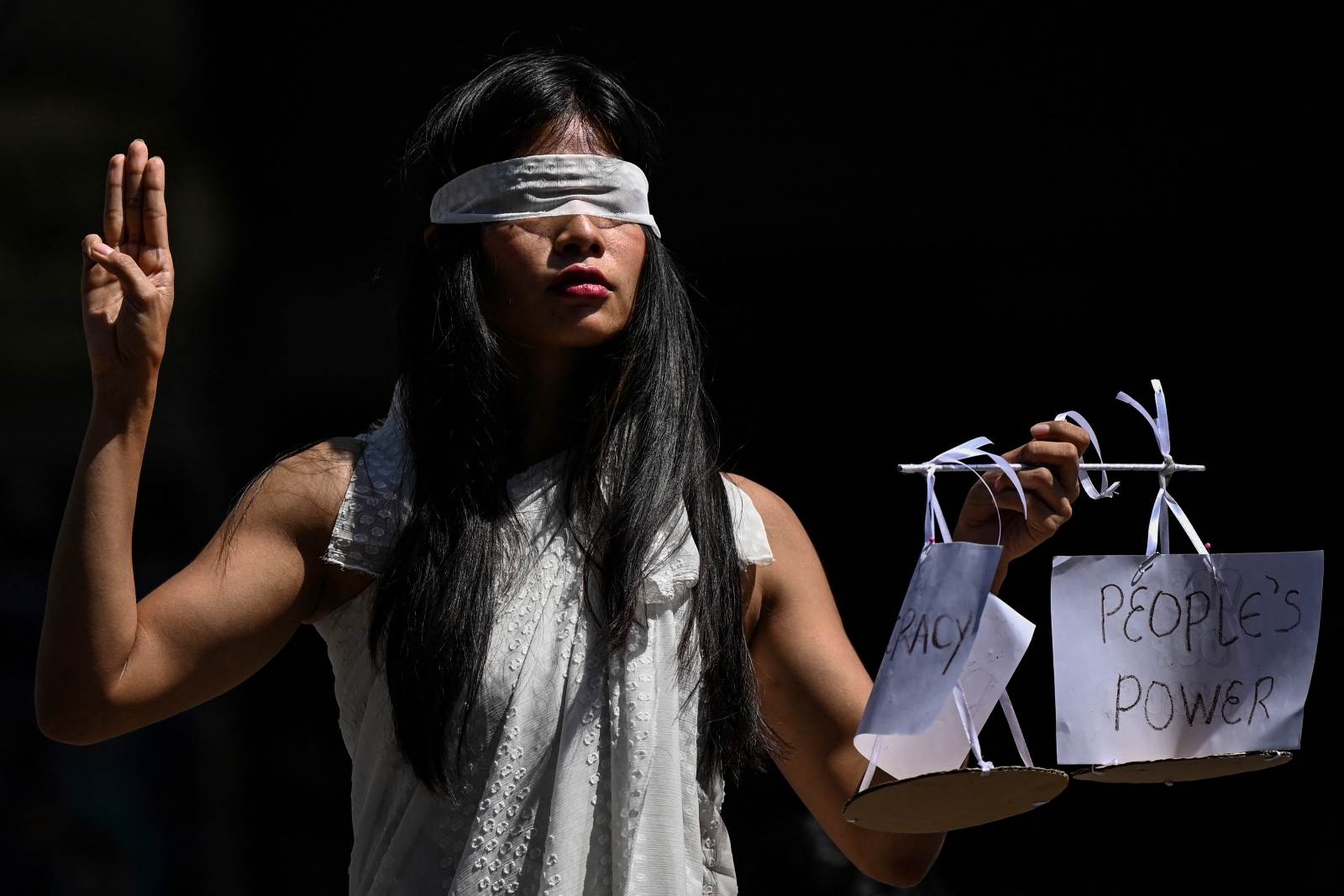 A protestor dressed as Lady Justice makes the three finger salute at a demonstration against the military coup in Yangon on February 11, 2021. (AFP)