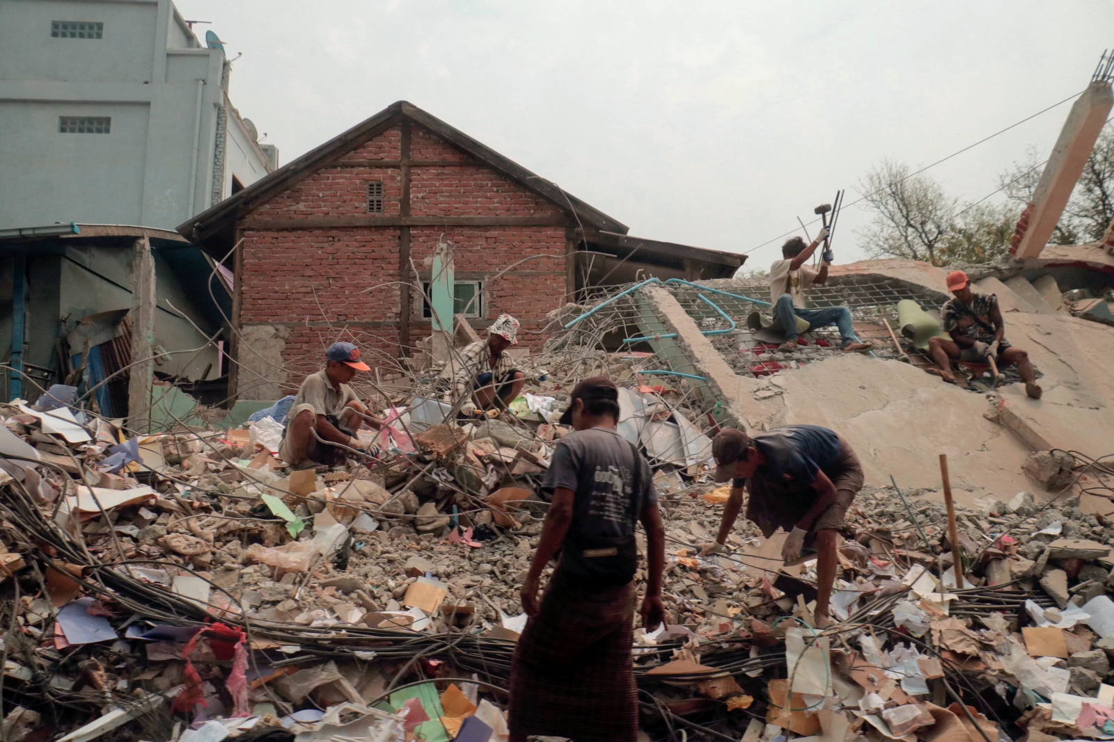 People sort through the rubble of a collapsed building in Mandalay on April 5. (AFP)