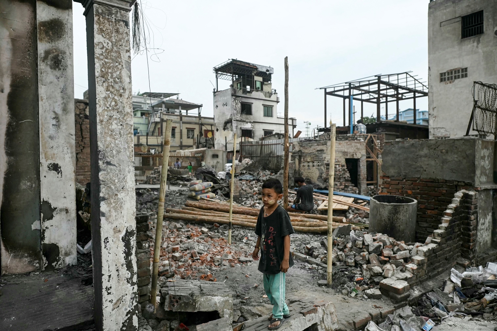 A boy stands among the debris of buildings destroyed by the March 28 earthquake in Mandalay on April 11. (AFP)