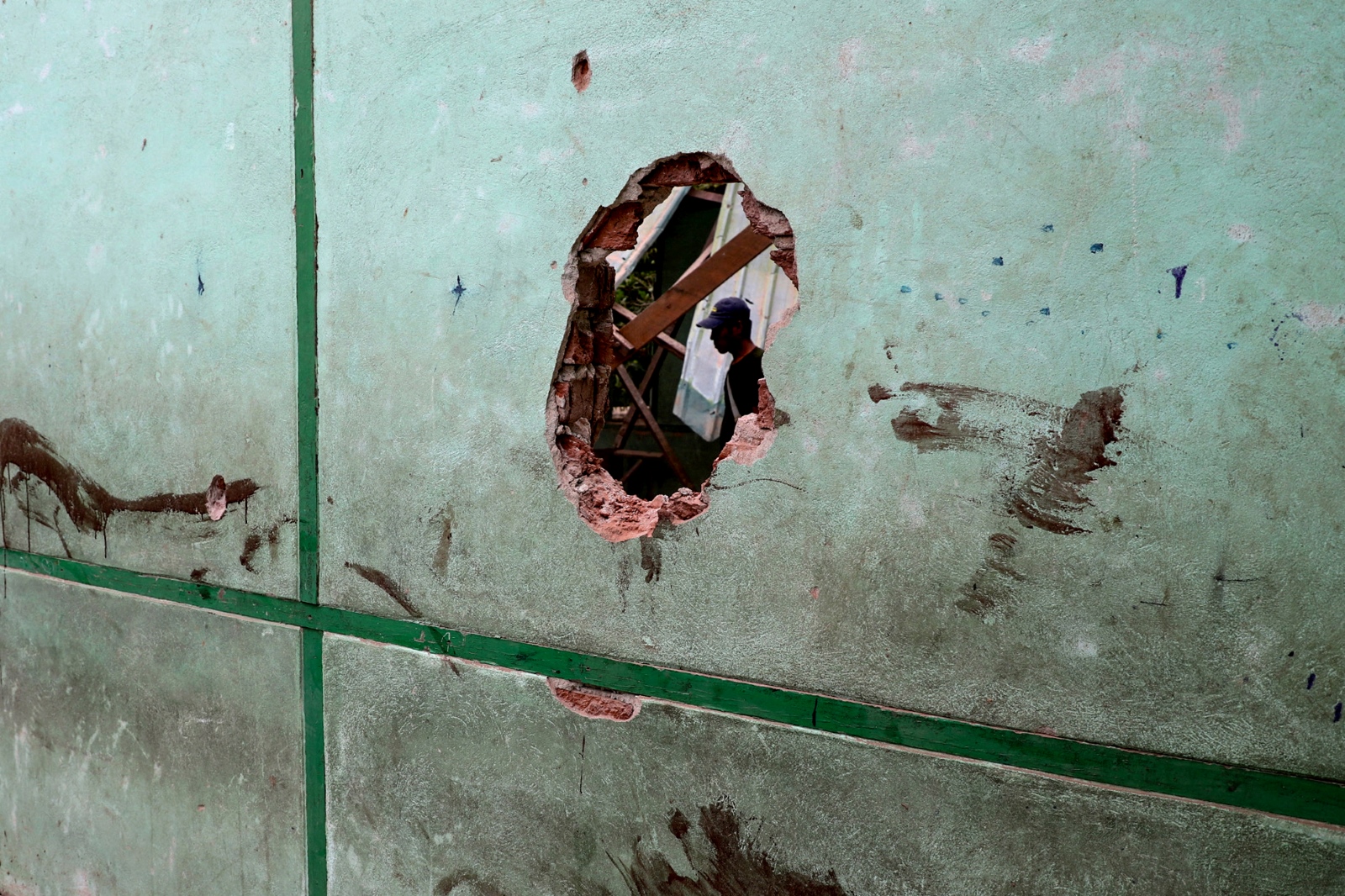 A man is seen through a damaged wall of a school in Oh Htein Twin village, in Sagaing Region’s Tabayin Township, following a regime airstrike on May 12. (AFP)