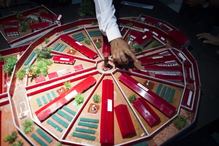 A former political prisoner points to a section of a model of Insein Prison where he was once held, during a 2018 exhibition at the University of Yangon. (AFP)