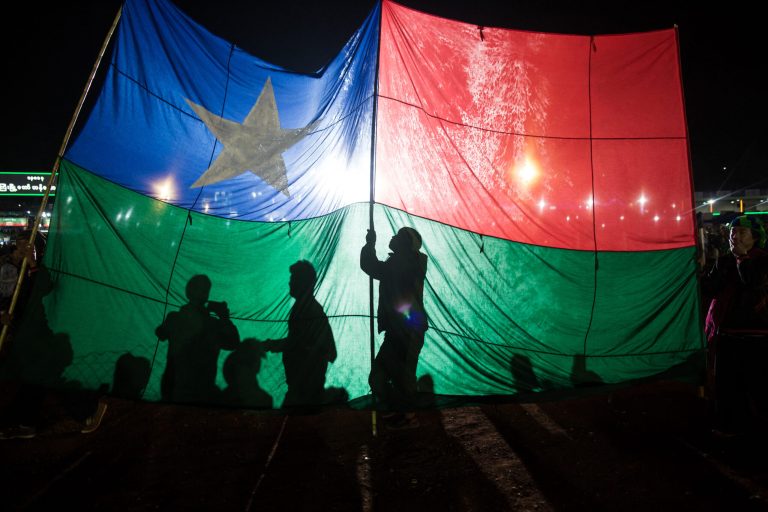 People hold a Pa-O flag as they release balloons attached with fireworks during the Tazaungdaing Festival in Taunggyi in southern Shan State. (AFP)