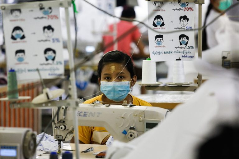 A worker sews disposable surgical gowns at a garment factory in Yangon in May 2020. (AFP)