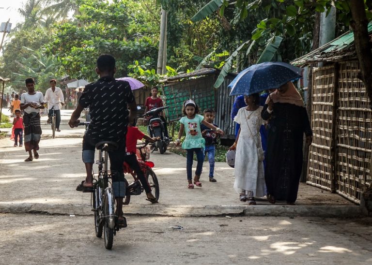 People walk along a street at the Aung Mingalar quarter for Rohingya Muslims as they observe the first day of the Eid al-Fitr holiday, which marks the end of the Islamic holy month of Ramadan, in Sittwe, Myanmar's Rakhine State on May 24, 2020. (Photo by - / AFP)