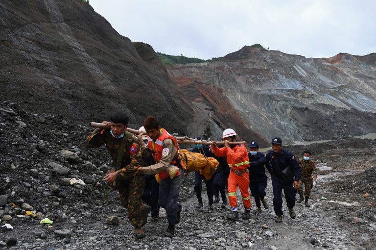 Myanmar soldiers and Red Cross workers carry a body recovered from the site of a landslide in Hpakant in Kachin State on July 4. (AFP)