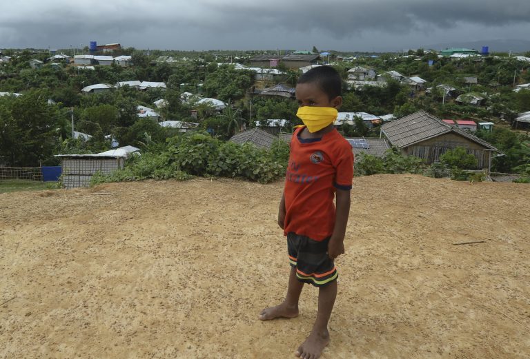 A young Rohingya refugee wearing a facemask as a preventive measure against COVID-19 stands on a hill in Kutupalong refugee camp on August 24. (AFP)