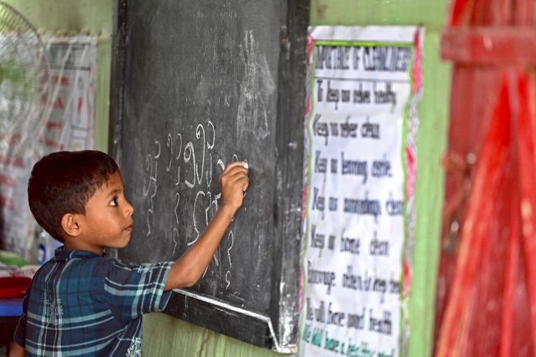 A Rohingya refugee child writes Rohingya language on a blackboard at a school in Kutupalong refugee camp in August. (Munir uz Zaman / AFP)