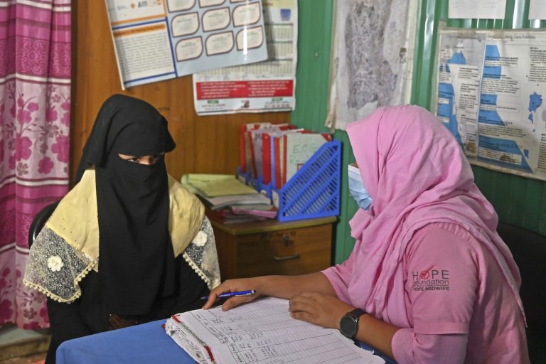 A health worker speaks with a Rohingya refugee in a maternity ward of a medical centre in Kutupalong refugee camp in August. (Munir uz Zaman / AFP)