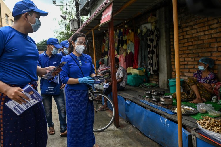 People's Pioneer Party chairperson Thet Thet Khine, right, gives out campaign literature to street vendors with other party members on September 8. (AFP)