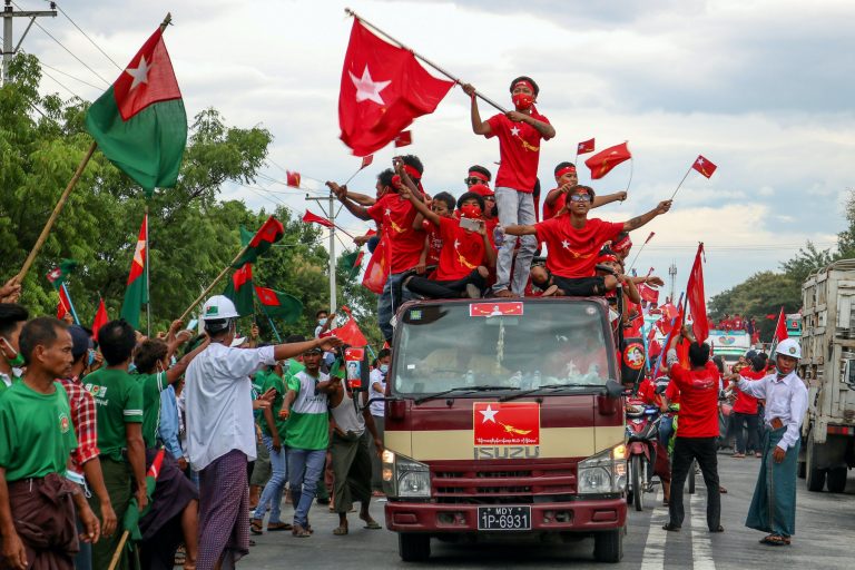 Supporters of the National League for Democracy party on a motorcade pass supporters of the opposition Union Solidarity and Development Party, left, during a campaign in Wundwin, near Mandalay on September 19. (AFP)