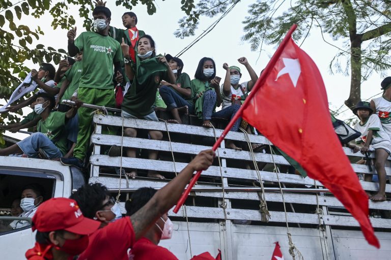 NLD supporters pass supporters of the pro-military USDP during an election campaign event on the outskirts of Yangon in November 2020. (AFP)