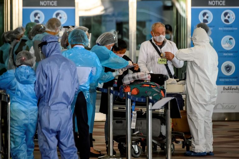 Employees in personal protective equipment at Bangkok's Suvarnabhumi Airport direct arriving international passengers to hotels for compulsory 14-day quarantines on November 16. The country has kept its COVID-19 case numbers low throughout the pandemic, but a cluster linked to Tachileik, Shan State, has Thai health authorities concerned. (AFP)