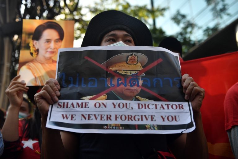 A Myanmar migrant holds up a poster with the image of Tatmadaw commander-in-chief Senior General Min Aung Hlaing at a demonstration outside the Myanmar embassy in Bangkok on February 1. (AFP)