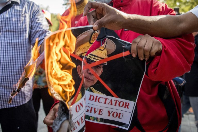 Protesters burn an image of Min Aung Hlaing in front of the United Nations building in Bangkok in February 2021. (AFP)