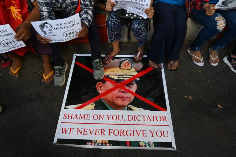 Protesters step on a banner with an image of Senior General Min Aung Hlaing during a protest in Yangon on February 11. (Frontier)