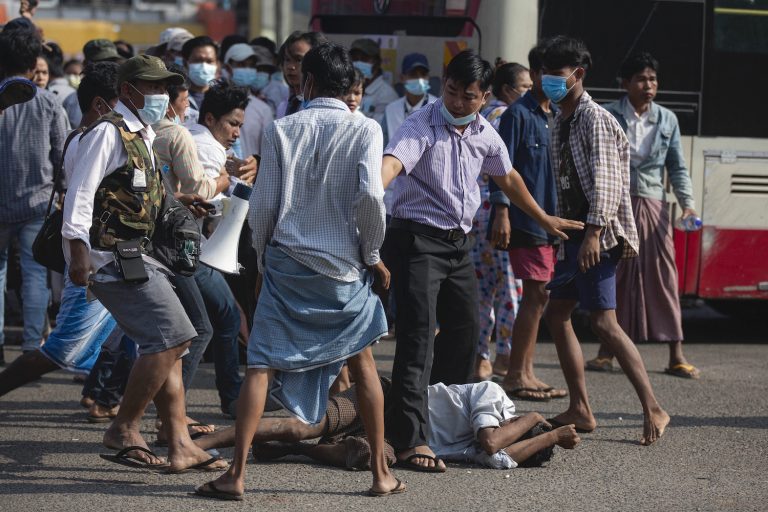 Military supporters attack an anti-coup protester during a demonstration in February 2021. (AFP)