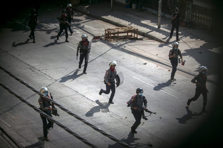 Police run towards protesters to disperse a demonstration being held against the military coup in Yangon on March 3. (AFP)