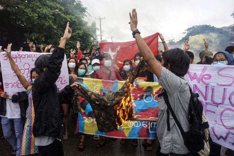 Protesters burn a military uniform as they take part in a flash mob demonstration against the military coup in Yangon in July 2021. (AFP)