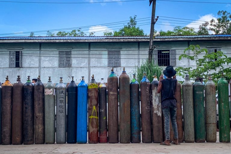 People line up to fill oxygen cylinders outside a factory in Yangon on July 14. (AFP)