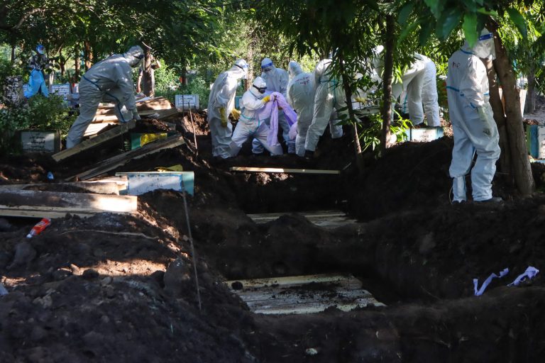 Volunteers wearing personal protective equipment bury the bodies of people who died from the Covid-19 coronavirus after their funeral at a cemetery in Mandalay on July 14, 2021. (AFP)