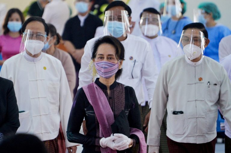 Aung San Suu Kyi wears personal protective equipment while overseeing vaccinations at a Nay Pyi Taw hospital in January 2021, days before the coup (AFP)