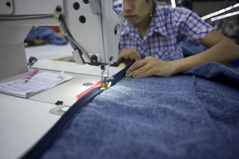 An employee sews clothes at a garment factory at the Shwepyithar industrial zone in Yangon. (AFP)