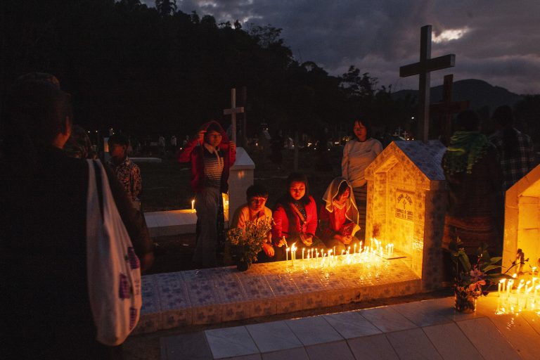 A Karenni family prays over the tomb of a young man killed during the war with the junta.