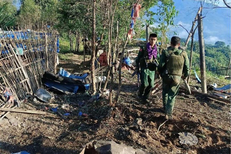 MNDAA fighters walk past a military base after seizing it during clashes in Laukkai Township, in northern Shan State, on October 28. (Kokang Information Network | AFP)