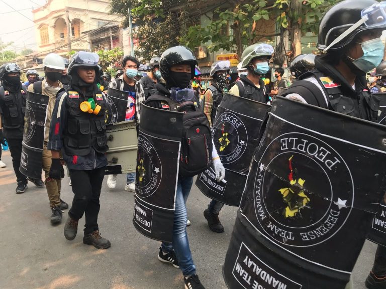 Pro-democracy protesters are seen on March 13 carrying makeshift shields to defend themselves from increasingly lethal crackdowns by security forces in Mandalay. (Frontier)