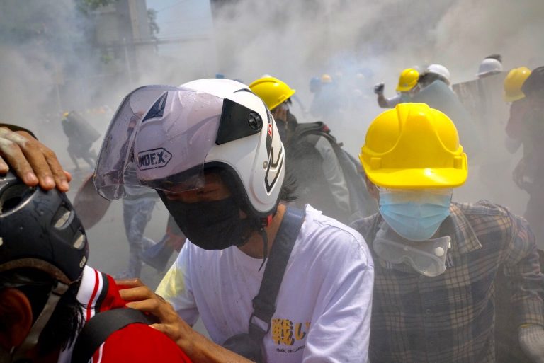 Protesters are caught in a cloud of tear gas near Insein Road late this morning. (Frontier)