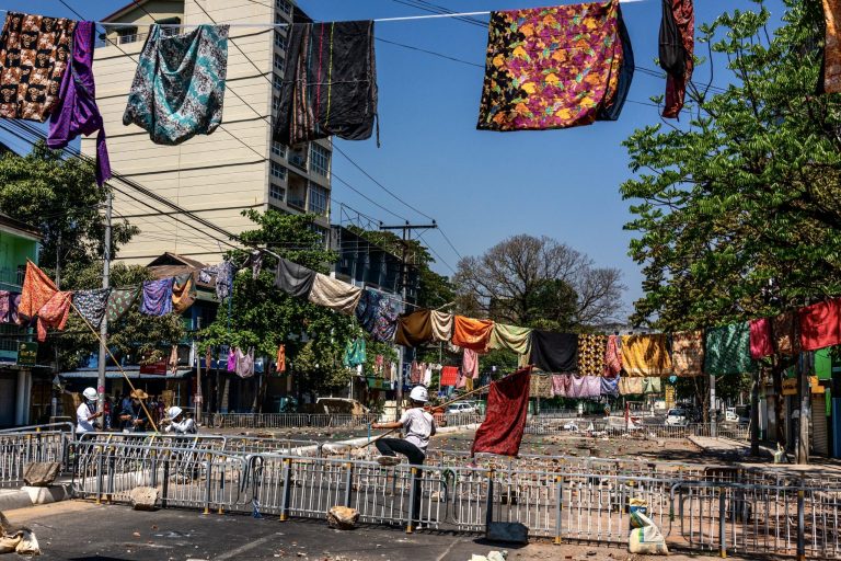 Rows of htamein hang above lines of barricades in the Kyaukmyaung area of Tarmwe Township on March 8. The women's garments are hung to deter superstitious members of the security forces. (Frontier)