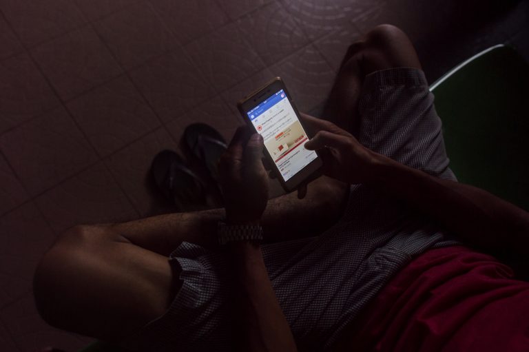 A man uses Internet on a mobile phone in Yangon on June 7, 2018. (AFP)