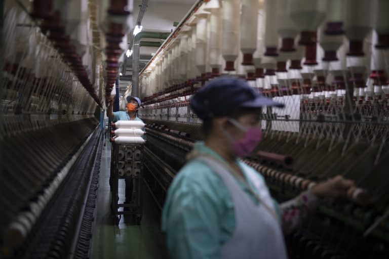 Myanmar migrant workers handle cotton thread spools in a textile factory in the Thai province of Pathum Thani on September 23, 2018. (AFP)