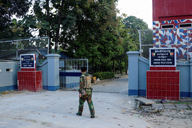 A Ta’ang National Liberation Army fighter walks past the police station in Namhkam town, northern Shan State, on November 9, 2023. (AFP)