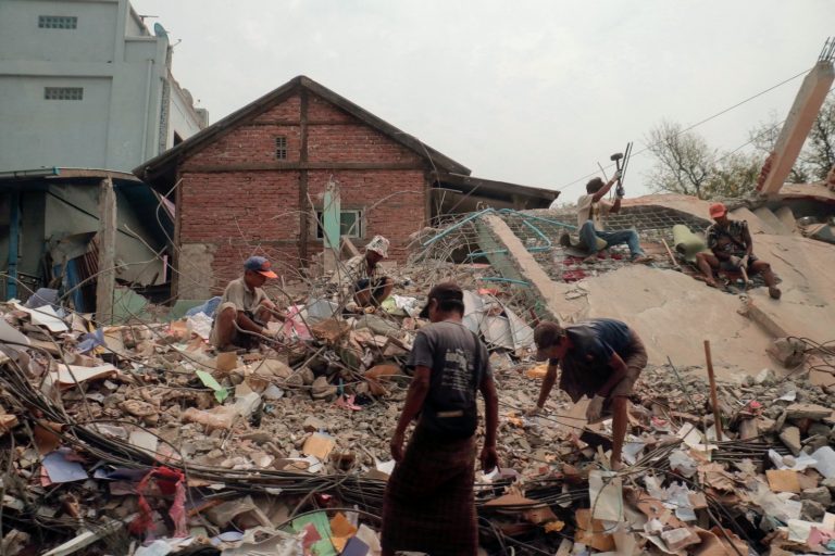 People sort through the rubble of a collapsed building in Mandalay on April 5. (AFP)