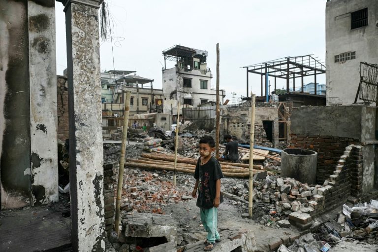 A boy stands among the debris of buildings destroyed by the March 28 earthquake in Mandalay on April 11. (AFP)