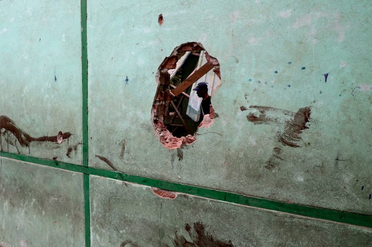 A man is seen through a damaged wall of the school of Oh Htein Twin village, in Sagaing Region’s Tabayin Township, following a regime airstrike on May 12. (AFP)