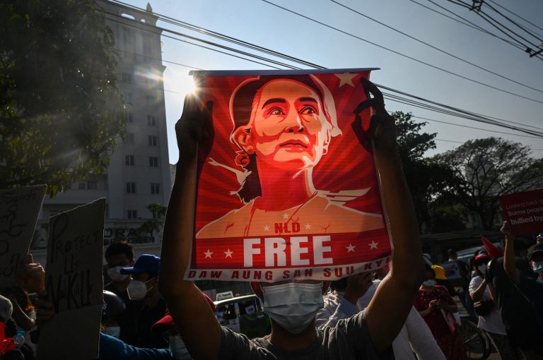 A protester holds up a poster of Daw Aung San Suu Kyi during an anti-coup demonstration outside the Central Bank building in Yangon on February 15. (AFP)