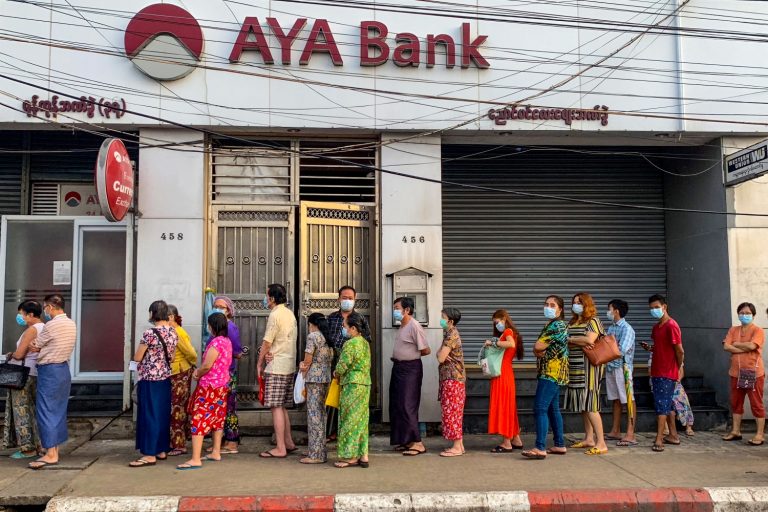 Yangon residents queue for cash outside a branch of AYA Bank on April 12. (AFP)