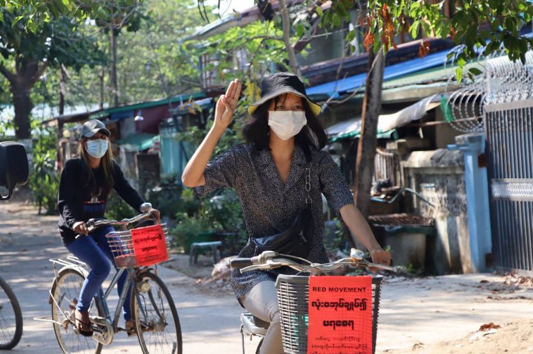 A Yangon resident raises the three-finger pro-democracy salute while protesting against military rule by bicycle on April 15. (Facebook / AFP)