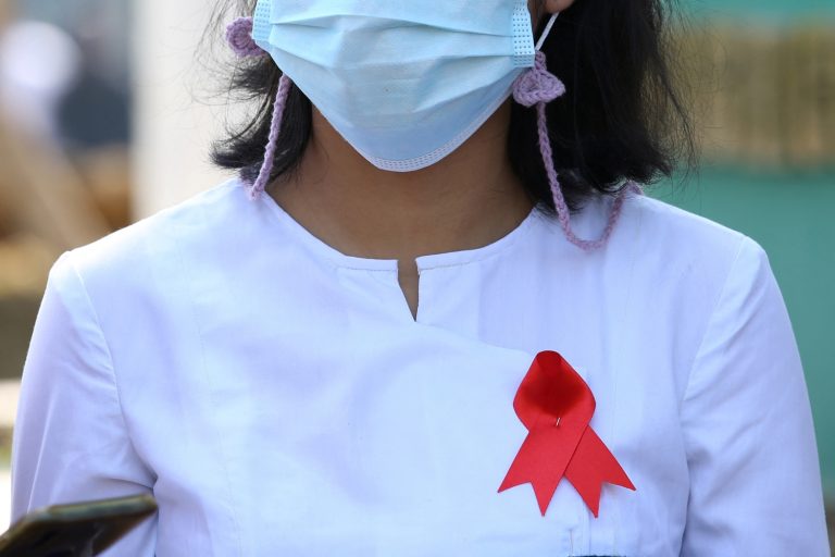 A Department of Agriculture staffer in Nay Pyi Taw on February 4 wears a red ribbon on her uniform to protest the coup. (AFP)