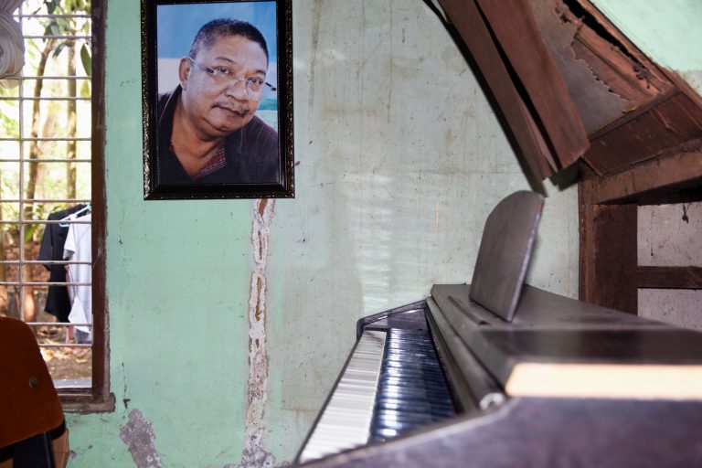 A portrait of songwriter and poet Naing Myanmar hangs above his piano at the family house in Yangon’s East Dagon Township. (Lu Po | Frontier)