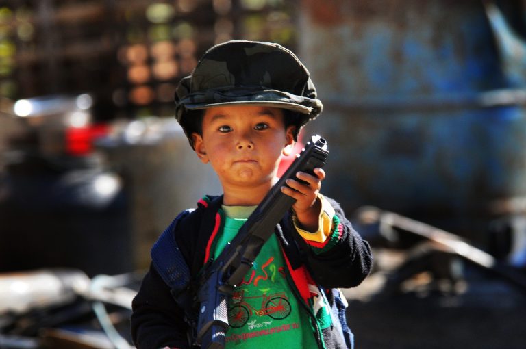 Just a few kilometres from the frontline south of the town of Laiza, a young boy plays with his toy gun outside his home in 2017 (Frontier).