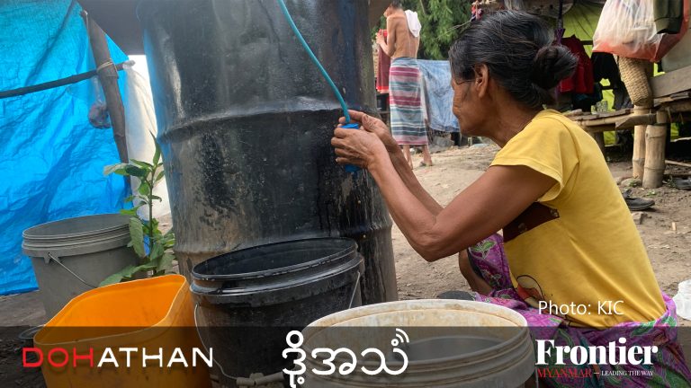 An elderly displaced woman collects water in a makeshift camp on the Thaung Yin River between Myanmar and Thailand. (Frontier)