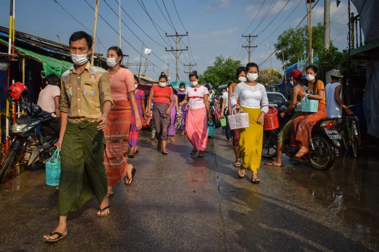 Yangon factory workers walk to work on May 16. The industrial workforce of the city largely consists of migrants from poor rural areas, many of whom are vulnerable to disenfranchisement because they are registered to vote elsewhere. (Kyaw Lin Htoon | Frontier)