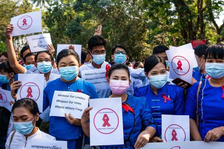 Members of the Yangon University Teachers' Association hold up the three-finger salute in protest of the military coup on February 5. (Frontier)