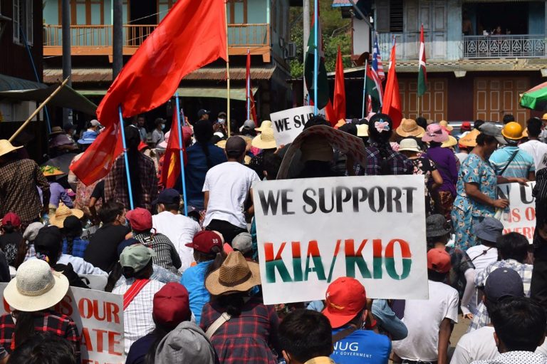 A protester holds a placard in support of the Kachin Independence Organisation and its armed wing, the Kachin Independence Army, during an anti-coup demonstration in the jade mining town of Hpakant in Kachin State on May 3. (Kachinwaves / AFP)