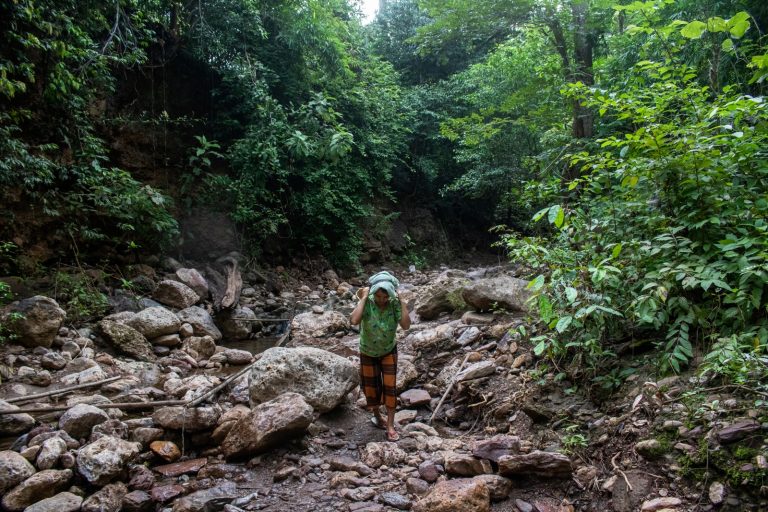 A woman carries water near a camp for internally displaced people in Kayah State’s Demoso Township on October 18, 2021. (AFP)